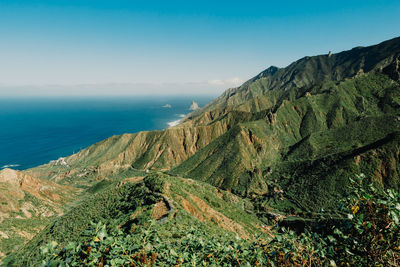 Scenic view of sea and mountains against sky