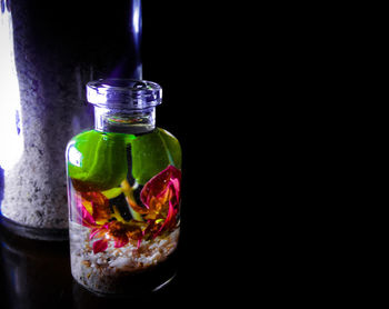 Close-up of glass of bottle against black background