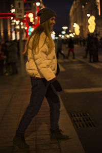 Full length of woman walking on street at night