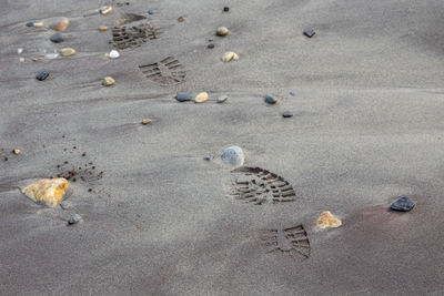 High angle view of shoe prints on sand at beach