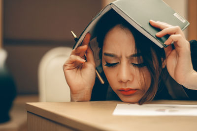 Close-up of young woman sitting on table