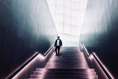 Rear view of man walking on staircase