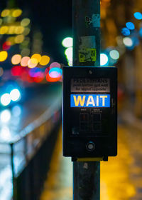 Close-up of illuminated information sign in city at night