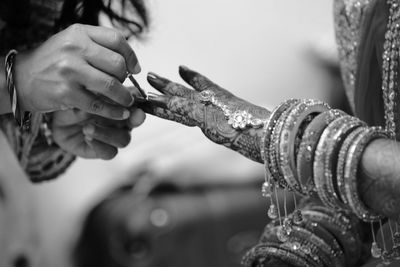 Close-up of woman applying nail polish on fingernails of bride