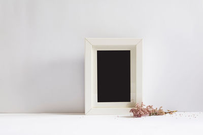 Close-up of blank picture frame against white wall