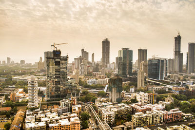 Aerial view of buildings in city against sky