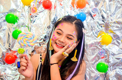 Smiling girl holding multi colored lollipop 