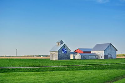 Houses on field against clear sky