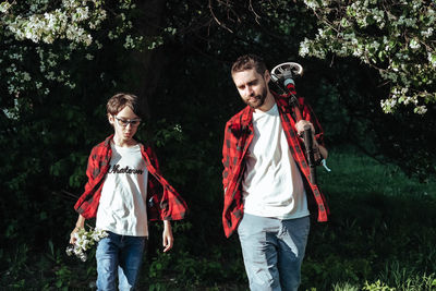 Full length of friends standing against trees