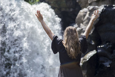 Rear view of woman standing in water