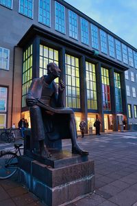 Statue against building in city