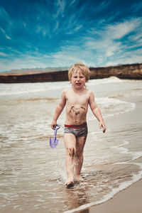 Portrait of shirtless boy standing at beach