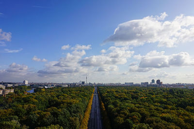 Panoramic shot of road by buildings against sky