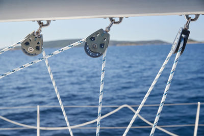 Close-up of rope tied to railing against sea