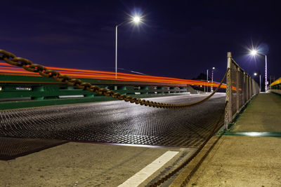 Illuminated bridge against sky at night