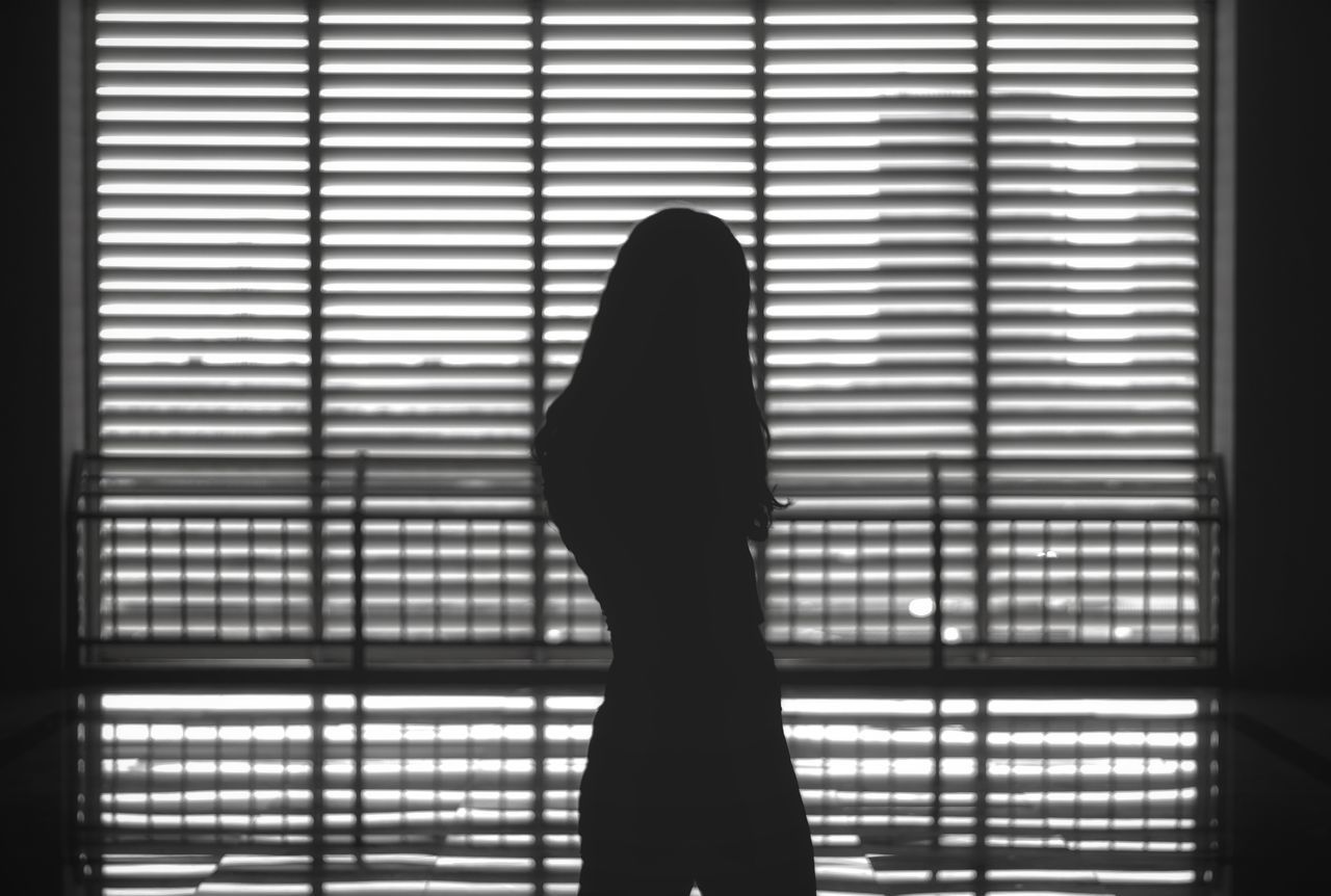 SILHOUETTE WOMAN STANDING BY WINDOW