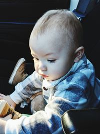 Close-up of cute boy sitting on sofa