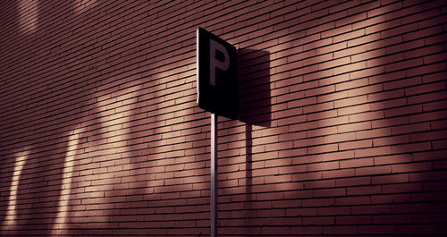 Low angle view of reflected light of a window on brick wall