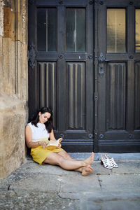 Woman sitting by closed door