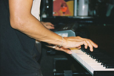 Midsection of man playing piano