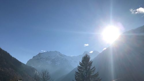 Scenic view of snowcapped mountains against sky on sunny day