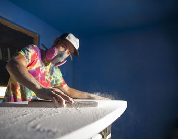 Man making surfboard in workshop