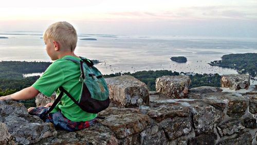 Watching the sunrise on stone tower atop mount batty camden, maine. father, son time. 