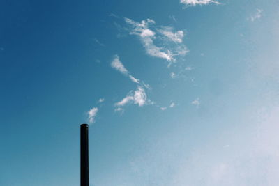 Low angle view of smoke emitting from chimney against sky