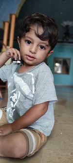 Portrait of cute boy sitting indoor