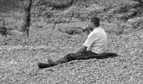 Full length of man sitting outdoors