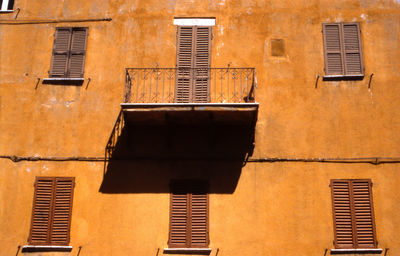 Balcony and it's shadow on a ochre colored wall