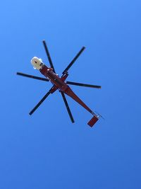 Low angle view of airplane against clear blue sky