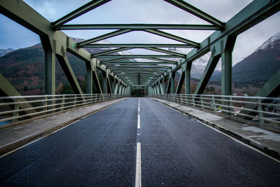 Empty bridge against mountains during winter