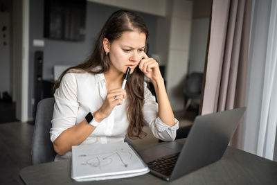 Young woman using laptop at home