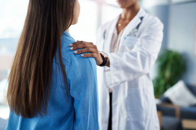 Midsection of female doctor holding hands