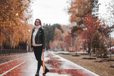 Full length portrait of woman standing in rain