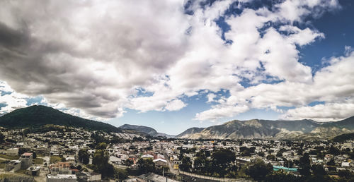 Aerial view of townscape and mountains against sky