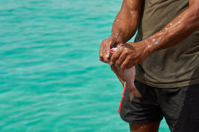 Low section of man holding water