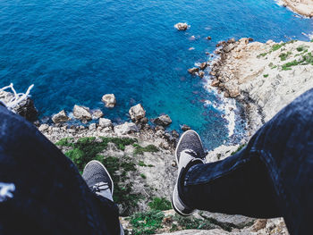 Low section of man on rock by sea