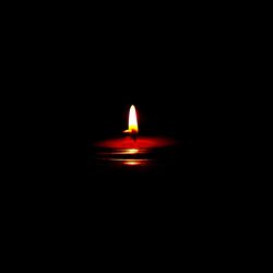 Lit candle in dark room