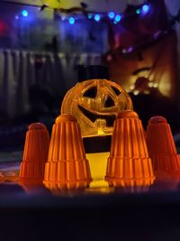 Close-up of illuminated pumpkin on table at night