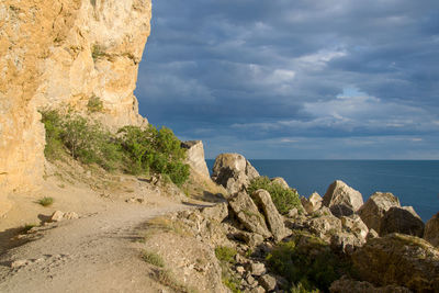 Rock formations by sea against sky