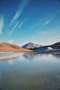 Scenic view of mountains against blue sky