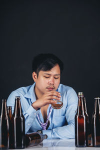 Young man drinking glasses on table