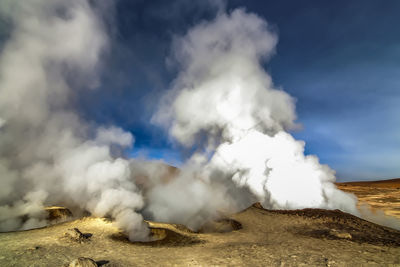 Smoke emitting from volcanic mountain against sky