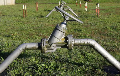 Close-up of pipeline on grassy field