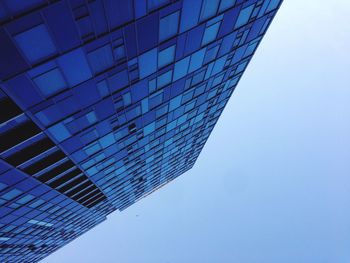 Low angle view of office building against blue sky