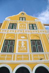 Low angle view of yellow building against sky