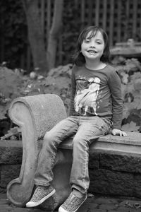 Portrait of young woman sitting on rock