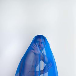 Low section of woman holding water against white background